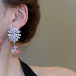 Close-up of silver wheat floral earrings featuring sparkling marquise and pear-cut zircons