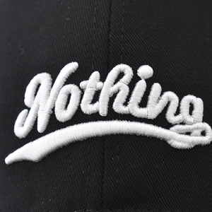 Black cotton baseball cap featuring 3D white Nothing cursive embroidery detail