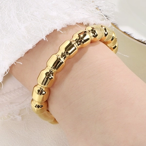 Detailed shot of an 11mm hollow C-shaped open bangle in 18k gold plated stainless steel