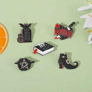 Dettaglio del set di 5 spille smaltate di Halloween con stivali da strega e simboli gotici