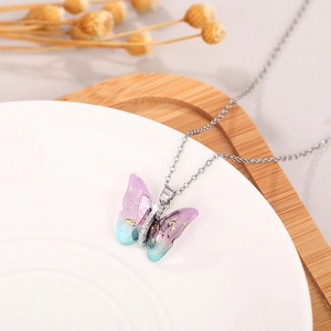 Macro detail of gradient purple and blue butterfly pendant with silver chain necklace