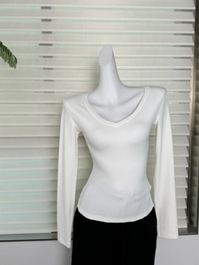 Détail d'un t-shirt blanc à col en V et manches longues avec texture finement côtelée