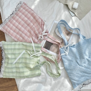 Flat lay of plaid tote bags in pink, green, and blue with lace bows and ruffles