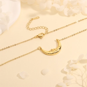 Macro detail of 18k gold crescent moon pendant featuring a small zircon and lobster clasp