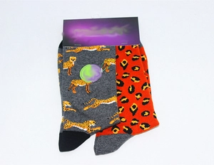 Detail view of cotton socks with grey cheetah pattern and orange leopard print