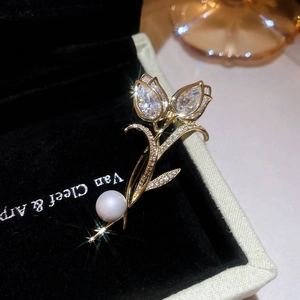 Macro detail of tulip brooch with 14K gold plating, sparkling zircons and a white pearl