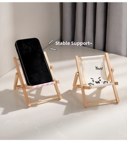 Detail showing the foldable mini beach chair phone stand with pink stripes and face print