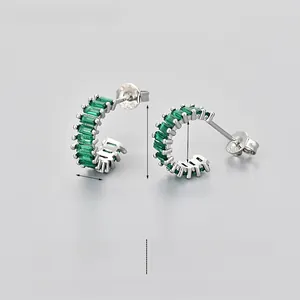 Macro shot of S925 silver hoop earrings featuring emerald-cut green cubic zirconia stones