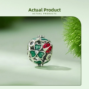 Macro view of S925 silver clover charm with red ladybug and green enamel detailing