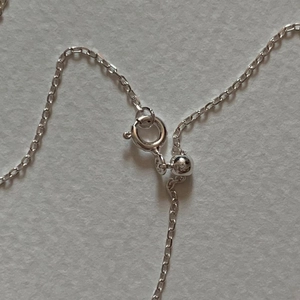 Macro detail of S925 sterling silver spring clasp and adjustable slider bead texture