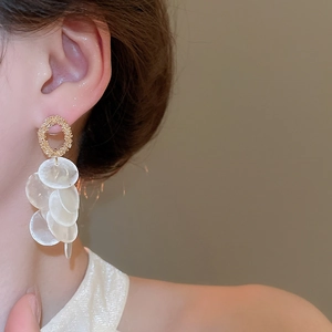 Detail of round shell tassel earrings with golden matte ring on a side-view model