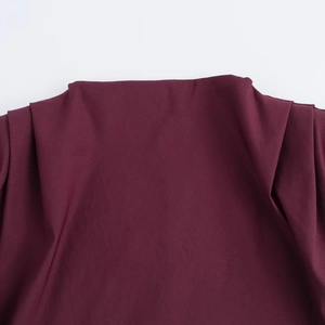 Macro shot of burgundy pleated fabric detailing on the sleeveless padded shoulder top