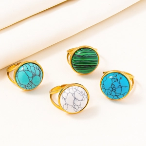 Detail view of a 4-piece ring set with colorful stones on white textured fabric