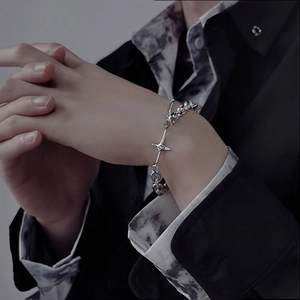 Men's silver hip-hop chain necklace with a star pendant styled on a wrist