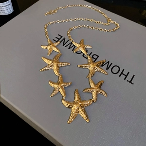 Detailansicht der goldenen Seestern-Halskette mit Hammerschlag-Textur und Karabiner