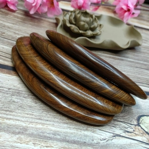 Macro detail of five dark sandalwood hair combs showing natural wood grain and textures