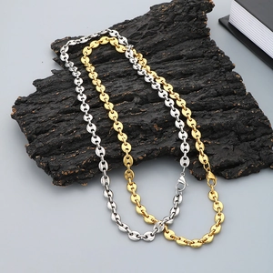 Chic 18k gold and silver coffee bean link chains on rustic bark in professional flat lay