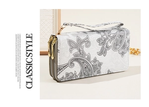 Close-up of double zipper closure and grey paisley print on white synthetic leather purse