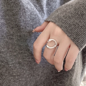 Close-up of minimalist 925 sterling silver U-shaped ring on model hand with knit sweater