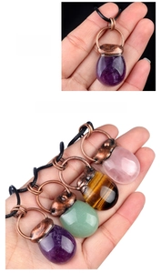 Macro detail of drop-shaped amethyst and gemstone pendants with vintage copper metal caps