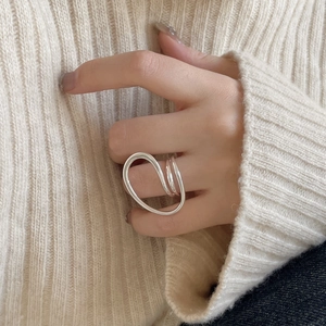 Macro detail of polished S925 sterling silver twisted ring on a knit texture background