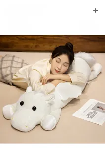 Detailed view of large white plush horse pillow with small wings in home bedroom setting