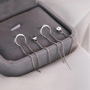Orecchini a catena con luna in argento presentati in una scatola portagioie in velluto grigio