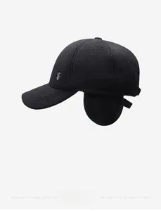 Detail of winter baseball cap with warm ear flaps and side silver metal shield logo