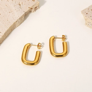 Detail view of minimalist gold U-shaped earrings displayed on white background
