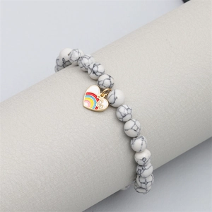 Natural white marble beaded bracelet featuring a gold-edged rainbow enamel heart charm