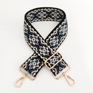 Close-up of ethnic jacquard strap with diamond pattern and gold metal swivel hooks