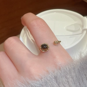 Close-up of 18k gold-plated open ring with round tiger eye stone on finger