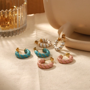 Three pairs of colorful C-shaped striped earrings in white, blue and pink enamel