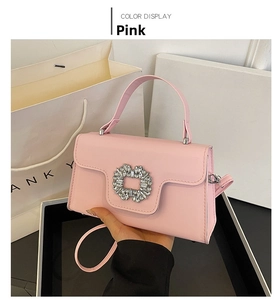 Detalle del bolso bandolera de cuero rosa claro con cierre de pedrería y asa superior