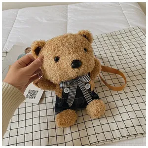 Detail of cute teddy bear plush bag with denim overalls and woven shoulder strap