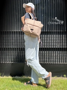 Gros plan sur un sac à dos matelassé kaki avec boucle élégante et texture douce