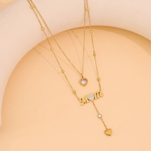 Double-layered gold necklace with heart gemstone and MOM pendant featuring tassels