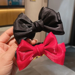 Detail shot of black and red silk bow hair claws for elegant bun hairstyles