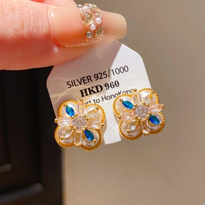 Vue macro détaillée de boucles d'oreilles S925 dorées avec perles et pierres bleues fines