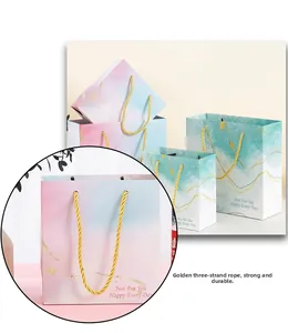Detail of durable golden triple-strand rope handles on gradient gift bags with foil stars