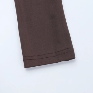Detail of dark brown ribbed knit fabric showing high-quality double-needle stitching