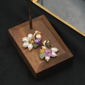 Détail macro de boucles d'oreilles perles dorées avec pierres naturelles violettes