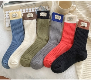 Flat lay of six pairs of knit wool socks with Something Better labels and ribbed texture