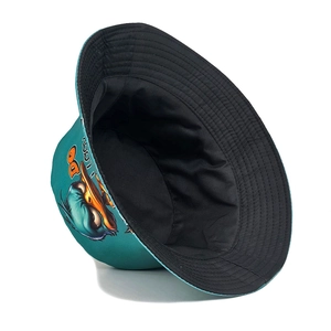 Reversible bucket hat with cartoon duck print in teal blue and solid black cotton fabric