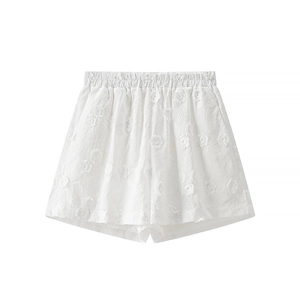 Detailed close-up of white elastic waist shorts with 3D floral embroidery patterns