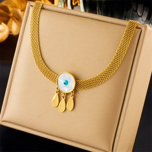 Gold evil eye necklace with mother of pearl and teardrop pendants on a jewelry box