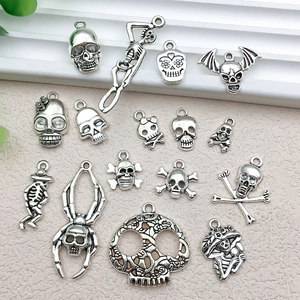 Detailed flat lay of vintage silver skull charms and skeleton alloy jewelry pendants