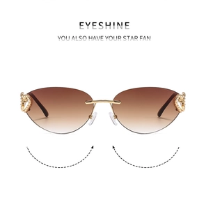 Detail of rimless Y2K sunglasses with gold heart-shaped metal hinge and crystals