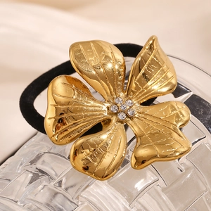 Macro shot of 18K gold plated flower hair tie with sparkling rhinestone center