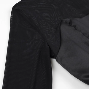 Détail des manches en maille et du tissu à l'épaule sur une robe noire élégante